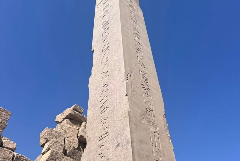 Ancient granite obelisk against a blue sky in Upper Egypt